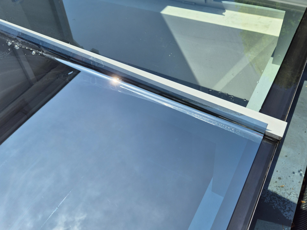 Sonnenschutzfolie – reflektierende Fensterfolie auf Glasfassade, installiert von Plottwerkstatt. vorher/nachher